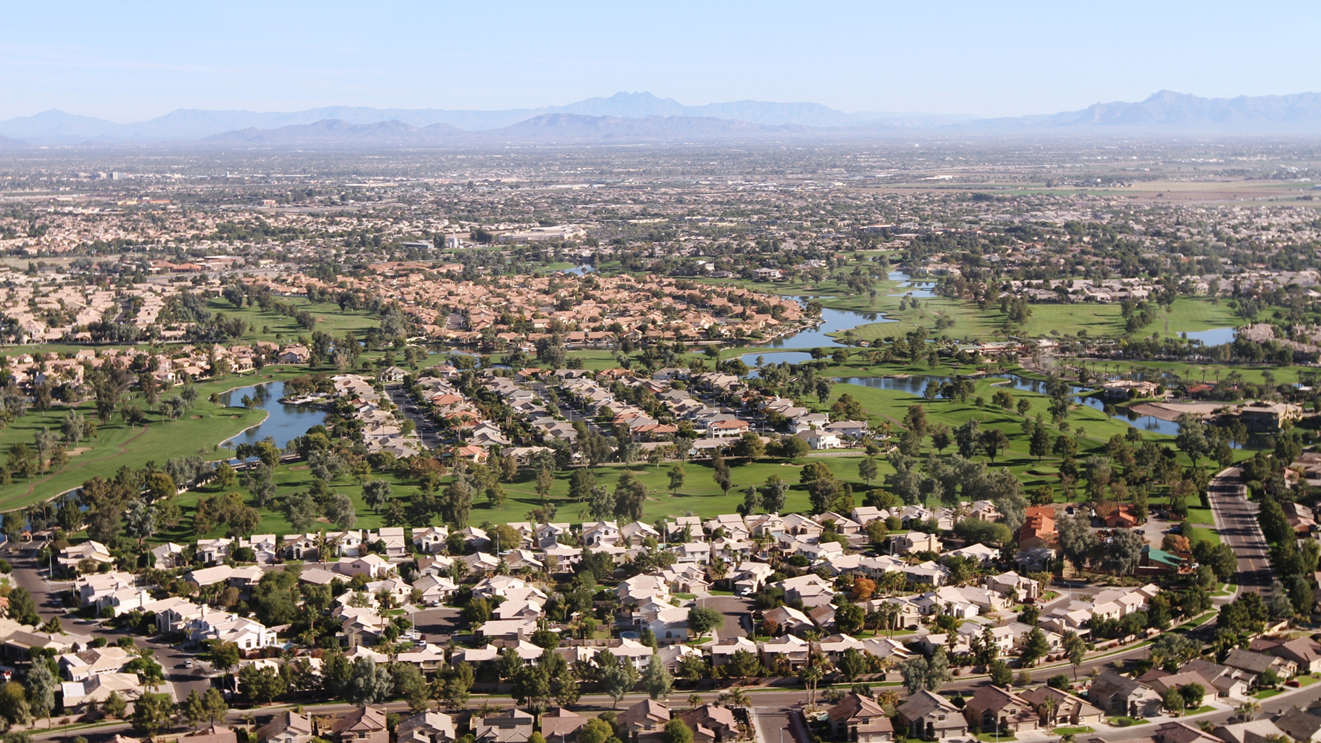 Aerial view of Chandler, Arizona neighborhoods with lakes and golf courses
